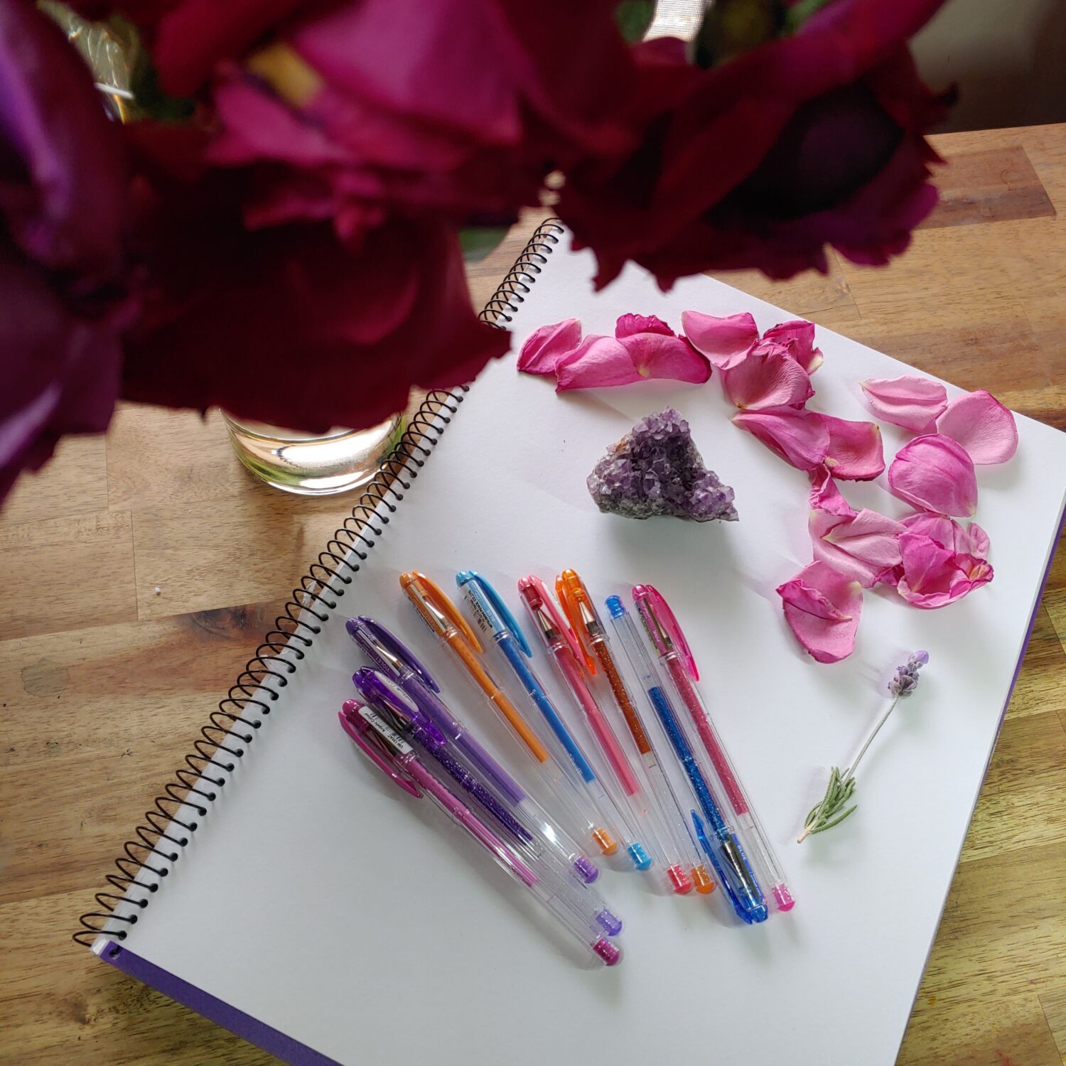 Journal with pens, rose petals and crystals